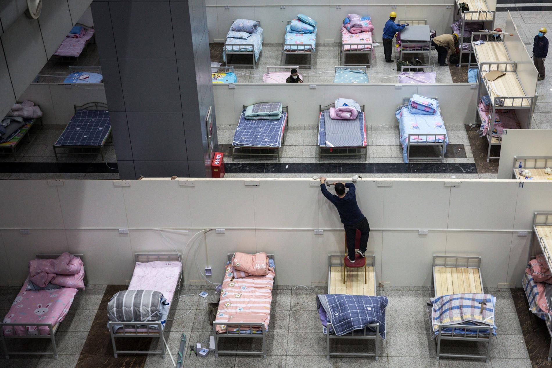 工人在武漢國際會展中心布置病床。PHOTOGRAPH BY GETTY IMAGES