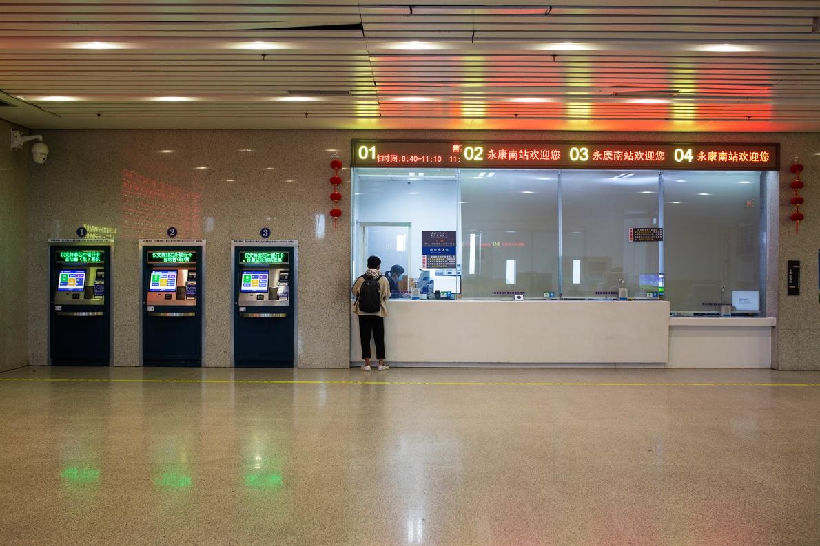 空蕩蕩的高鐵站裡，有一位想買票的旅客。因為全國各地交通禁令的關係，許多人都回不了家。PHOTOGRAPH BY ROBAN WANG, NATIONAL GEOGRAPHIC