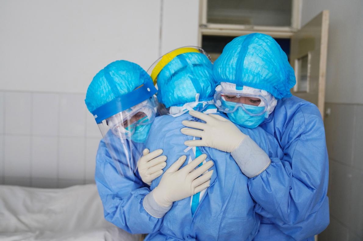 在中國山東省鄒平市的一間醫院裡，醫護人員在隔離病房內擁抱彼此。PHOTOGRAPH BY STR/AFP VIA GETTY IMAGES