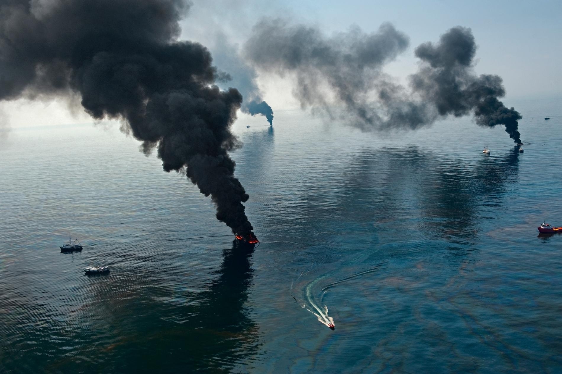 2010年4月深水地平線漏油事件後的墨西哥灣，煙霧從被清除人員點燃的表面油污中升起。PHOTOGRAPH BY JOEL SARTORE, NAT GEO IMAGE COLLECTION
