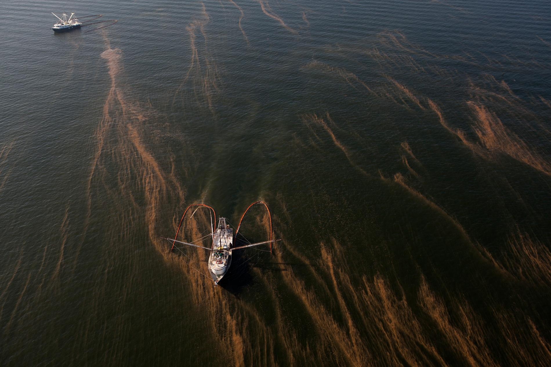 船隻利用圍油欄（absorbent booms）來攔捕深水地平線漏出來的油。PHOTOGRAPH BY TYRONE TURNER, NAT GEO IMAGE COLLECTION