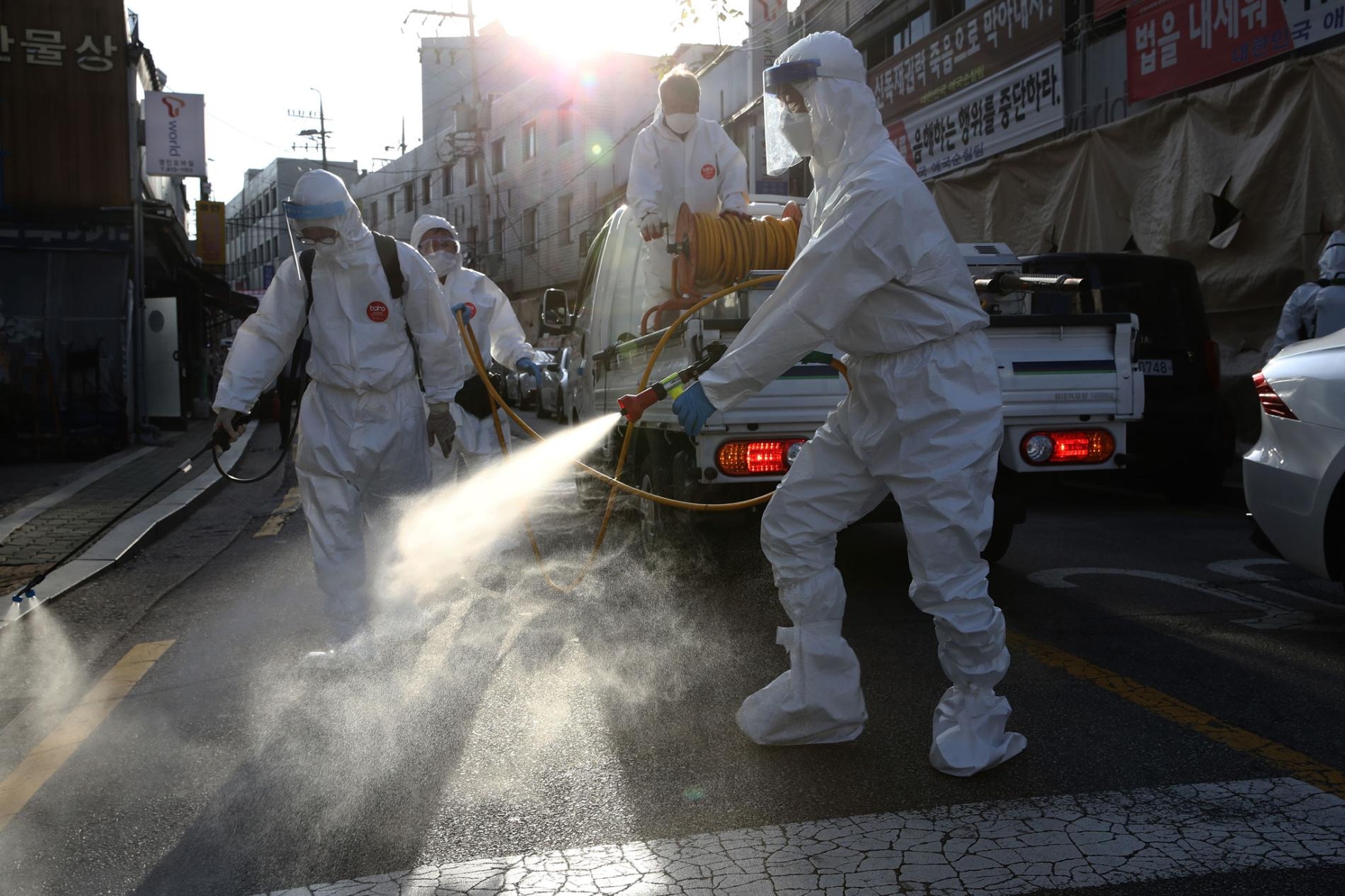 2020年10月6日南韓首爾，穿戴個人防護裝備的消毒工人在清理一條街，以預防冠狀病毒傳播。南韓的新型冠狀病毒病例已經連續第六天維持在100例以下，但該國正在為秋夕假期之後可能發生的疫情復熾做準備，因為據報導當時有大量人群聚。PHOTOGRAPH BY CHUNG SUN-JUN, GETTY IMAGES