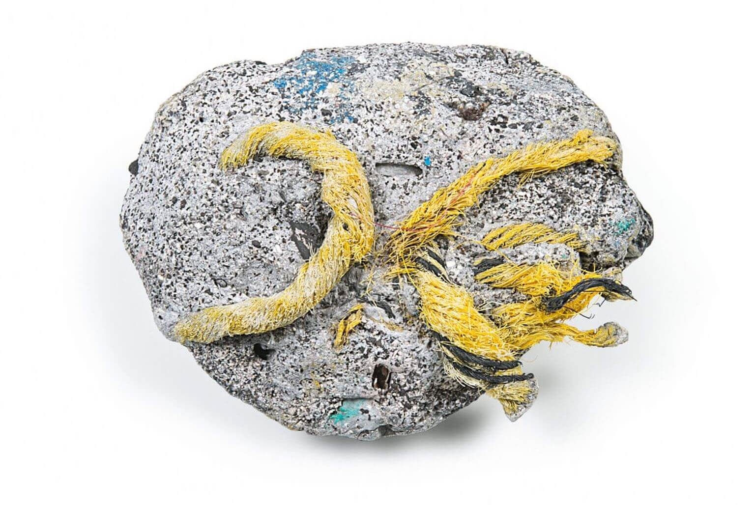 在夏威夷卡米羅岬海灘發現的「膠礫岩」，這是塑膠碎片熔化後（或許是營火造成），與沙子、岩石、貝殼及珊瑚融合而成的一種岩石。地質學家認為這種岩石將標記我們對地球的影響，而且存在時間會很長久。JEFF ELSTONE IDENTIFIED BY CHARLES MOORE, PATRICIA CORCORAN, AND KELLY JAZVAC