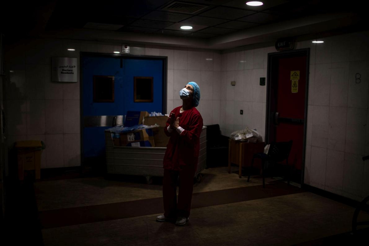 2021年1月15日黎巴嫩貝魯特南部，一名護理師在拉菲克哈里里大學醫院（Rafik Hariri University Hospital）的加護病房走廊內祈禱。雖然這場疫情大流行持續摧毀世界各地的社區，但疫苗接種行動與病毒監測最終可能會讓COVID-19更像是普通感冒。PHOTOGRAPH BY DIEGO IBARRA SANCHEZ, GETTY IMAGES
