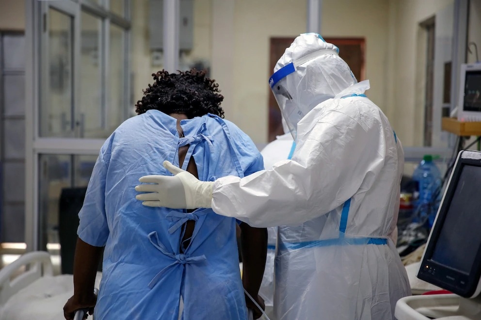 2020年11月3日，肯亞馬查科斯一間專門收治COVID-19病患的隔離與治療中心裡，一名醫護人員正在照顧一名住在加護病房的冠狀病毒患者。PHOTOGRAPH BY BRIAN INGANGA, AP 