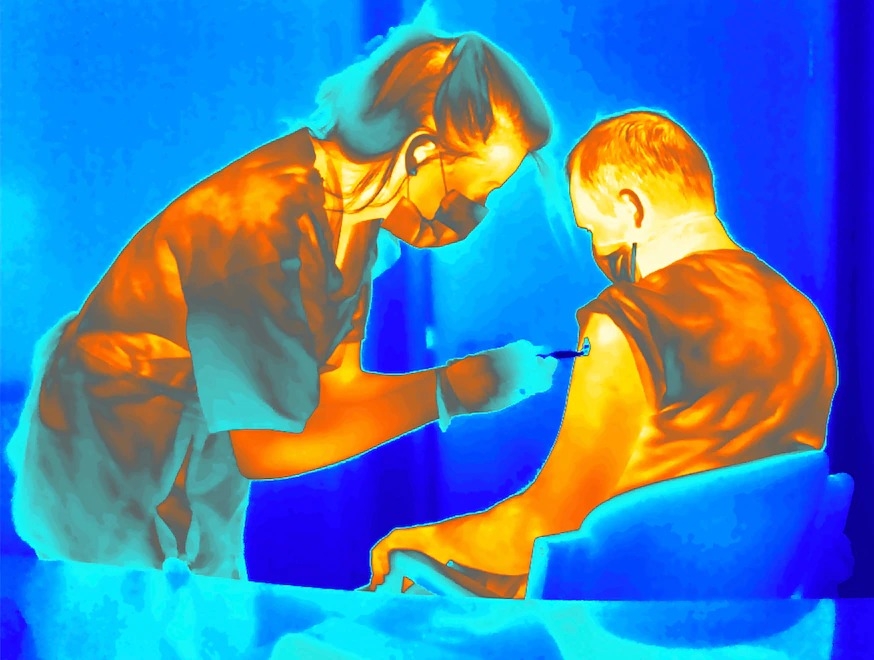 攝影師使用熱像儀來顯示醫護人員為病患注射牛津大學研發的冷藏COVID-19試驗疫苗。GILES PRICE,