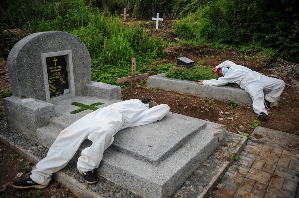 2021年6月15日印尼西爪哇省萬隆（Bandung），穿著防護服的工人在埋葬一名COVID-19死者之後休息。PHOTOGRAPH BY ANTARA FOTO, RAISAN AL FARISI, VIA REUTERS 