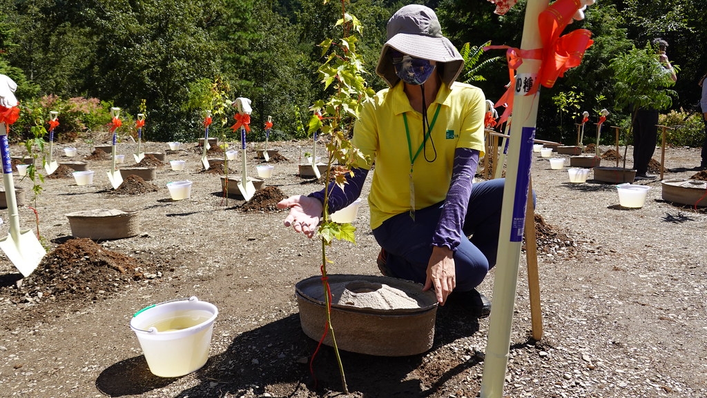 慈心基金會志工說明水寶盆使用方式，使用泥炭土栽植及添加有益菌的水進行澆灌，改良退化的土壤。孫文臨攝
