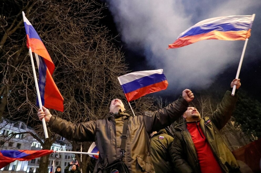 普丁簽署承認烏東兩個有俄羅斯撐腰的地區為獨立實體之後，親俄的行動分子在由分離主義者控制的頓內次克（Donetsk）街頭慶祝。煙火在他們身後爆開。PHOTOGRAPH BY ALEXANDER ERMOCHENKO, REUTERS 