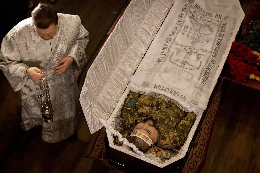 安東．奧列戈維奇．西多羅夫（Anton Olegovich Sidorov）上尉的棺木被抬到烏克蘭基輔的聖三一大教堂。烏克蘭軍方在2/26報告了這位士兵陣亡，他也是這波逐漸升級的衝突中第一批傷亡者。他是因為東部分離主義分子砲擊造成的致命彈片傷而陣亡。PHOTOGRAPH BY PIERRE CROM, GETTY IMAGES (上圖) AND PHOTOGRAPH BY CHRIS MCGRATH, GETTY IMAGES (下圖)