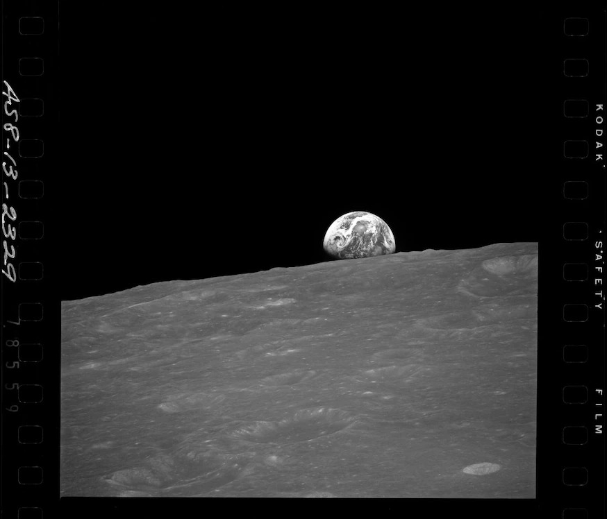 阿波羅8號（Apollo 8）的太空人弗蘭克．博爾曼（Frank Borman）、吉姆．洛維爾（Jim Lovell）和比爾．安德斯（Bill Anders）在1968 年拍攝了這張月球背面與遠方地球的照片。 最近，有個來源不明的廢棄火箭零件撞上月球背面，形成了一個新的撞擊坑。NASA