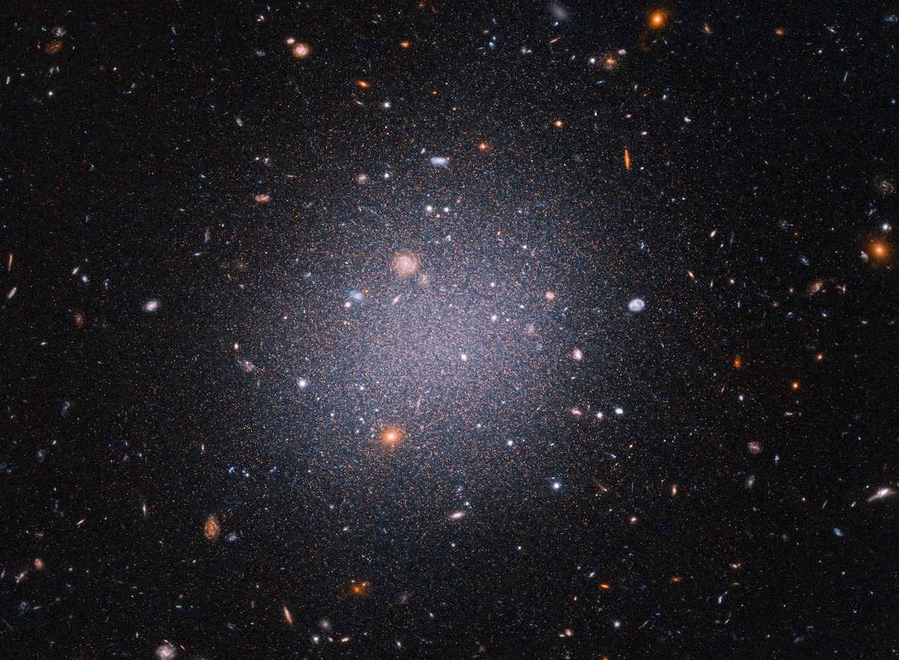 由哈伯太空望遠鏡拍攝的DF2星系影像，這是個距地球7200萬光年遠的獨特星系。天文學家一直對DF2缺乏暗物質的事實感到困惑，而暗物質像是能將星系結合在一起的隱形膠水。SCIENCE: NASA, ESA, STSCI, ZILI SHEN (YALE), PIETER VAN DOKKUM (YALE), SHANY DANIELI (IAS) IMAGE PROCESSING: ALYSSA PAGAN (STSCI)