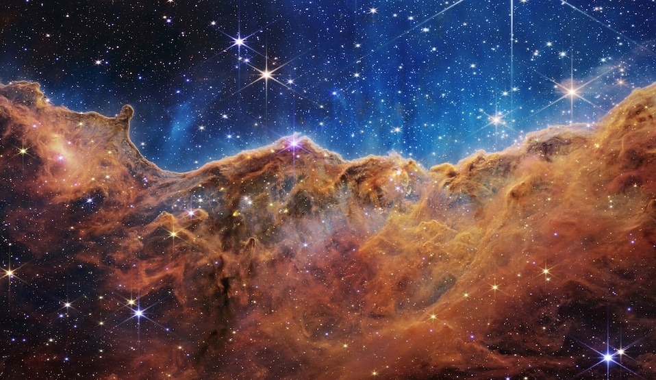 這張船底座星雲（Carina Nebula）的影像，看起來像是點綴著閃耀星光的山脈和峽谷。NASA的韋伯太空望遠鏡以紅外光拍攝到附近的NGC 3324恆星形成區域邊緣，讓我們首度看到先前未曾見過的恆星誕生區域。IMAGE BY NASA, ESA, CSA, AND STSCI