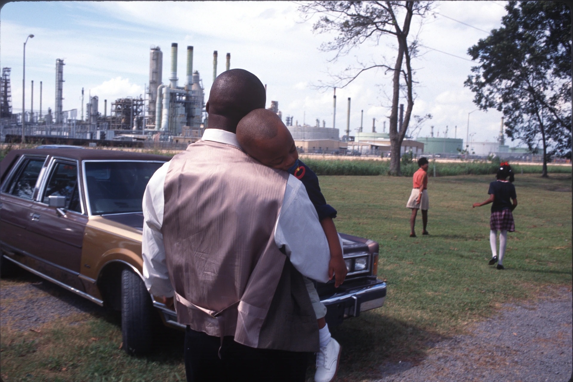 1998年在路易西安那州的來昂（Lion），這家人正離開他們的教堂，而教堂周圍都是化學工廠。這個沿著密西西比河畔的城鎮，靠近巴頓魯治（Baton Rouge），以癌巷（Cancer Alley）之名為人所知，因為罹癌率高，還有許多化學工廠和煉油廠。PHOTOGRAPHY BY ANDREW LICHTENSTEIN, CORBIS VIA GETTY IMAGES