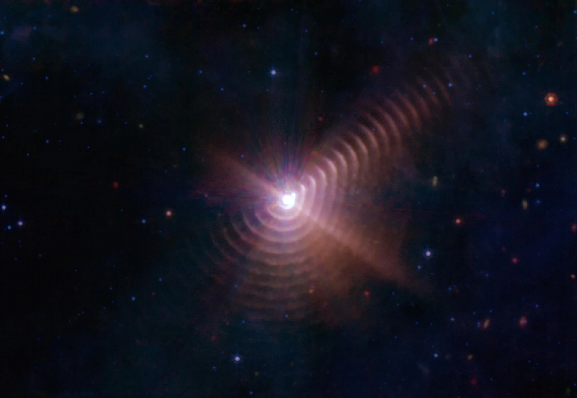 在這張韋伯影像中的宇宙塵埃殼層，看起來就像是沃夫－瑞葉（Wolf-Rayet）140周圍的樹木年輪。沃夫－瑞葉星處於生命週期的晚期，將重元素釋放到太空之中，而這顆恆星是雙星系統的一部分，其中一顆是已知最大質量恆星類型之一的O型星。殼層間距的顯著規律性顯示殼層就像是鐘錶的發條，是在雙星系統的八年軌道週期間，兩顆恆星彼此最接近時所所形成。IMAGE BY NASA/ESA/CSA/STSCL/JPL, CALTECH