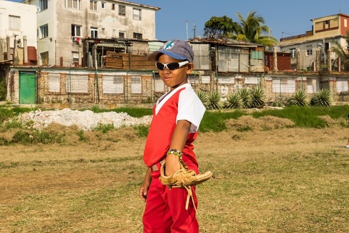 一名古巴小男孩在哈瓦那的小聯盟棒球賽中得意地戴著墨鏡。 PHOTOGRAPH BY IRA BLOCK , NAT GEO IMAGE COLLECTION 