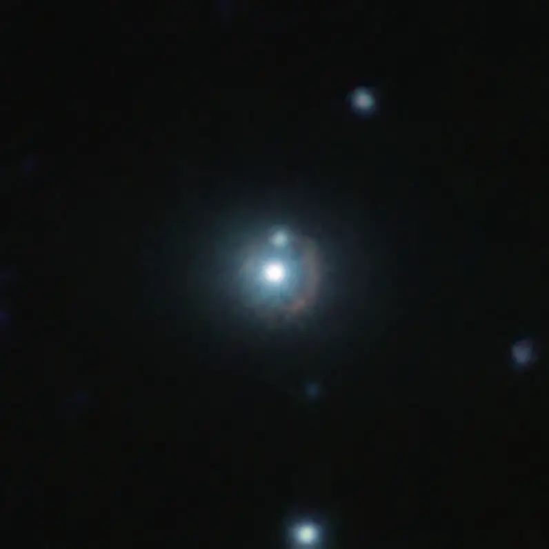 這張紅外線影像顯示遙遠的星系9io9，可以看到它是一條圍繞著明亮的附近星系彎曲的微紅色弧線。這個附近的明亮星系就像一個重力透鏡，它的質量使周圍的時空發生了彎曲，因此扭曲了背景中來自9io9星系的光線。此彩色影像是由歐南天文臺（ESO）位於智利的可見光和紅外巡天望遠鏡（VISTA），和位於夏威夷的加法夏望遠鏡（CFHT）拍攝的紅外線影像組合而成。圖片來源：ESO/J. Geach et al.