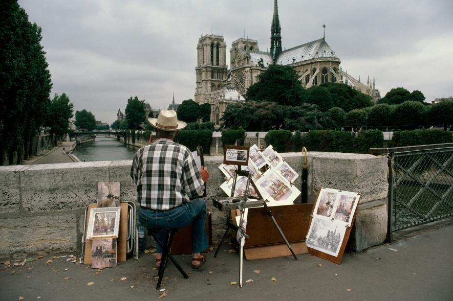  一位藝術家從大主教橋（Pont de L'Archeveche）上望著巴黎聖母院。PHOTOGRAPH BY WILLIAM ALBERT ALLARD, NAT GEO IMAGE COLLECTION
