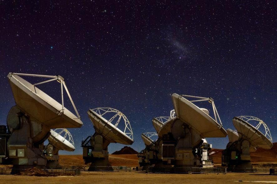 夜空微光下的66座阿塔卡瑪大型毫米及次毫米波陣列天線，它們是事件視界望遠鏡網路的重要成員。PHOTOGRAPH BY BABAK TAFRESHI