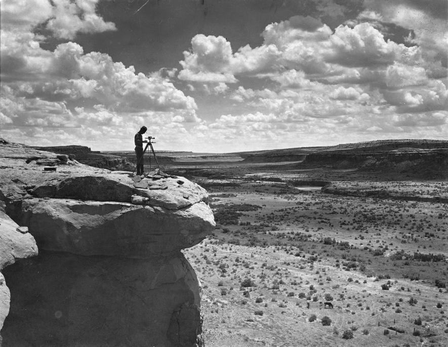 一名測量員站在峭壁上記錄查科峽谷的地形。PHOTOGRAPH BY NEIL M. JUDD, NAT GEO IMAGE COLLECTION
