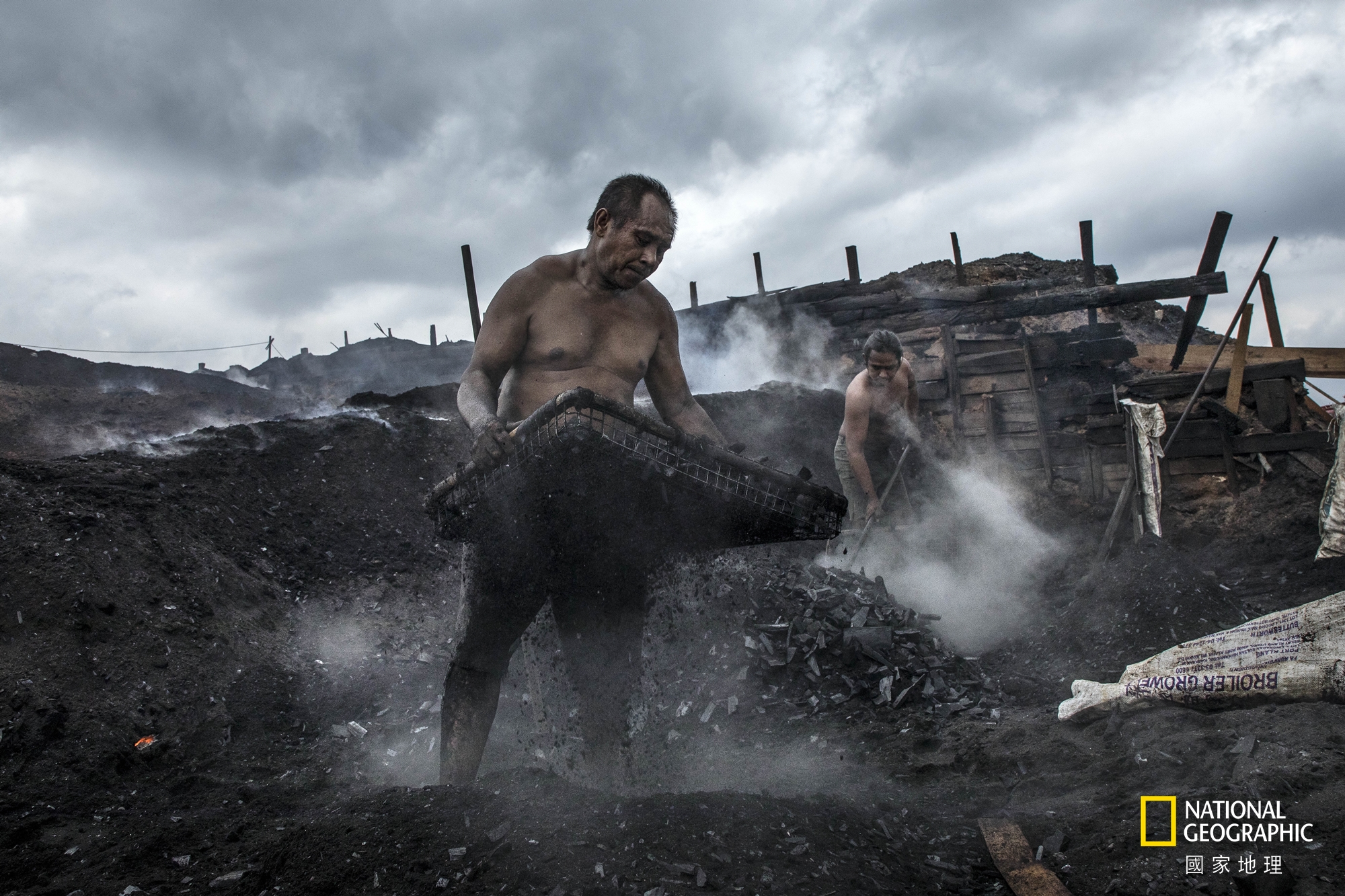 人物組冠軍：勤作 (攝影：張毅生)。在礦區的木炭移工不畏烈日風雨 , 每天勤奮地努力工作著。為了生活 , 儘管環境惡劣 , 仍要勇敢地奮鬥下去。